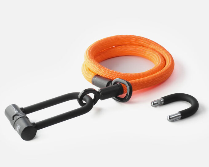 tex–lock eyelet in acid orange, maat M, in elkaar gewikkeld met X-lock aan het eind van het touw, kortere U-lock strik ernaast