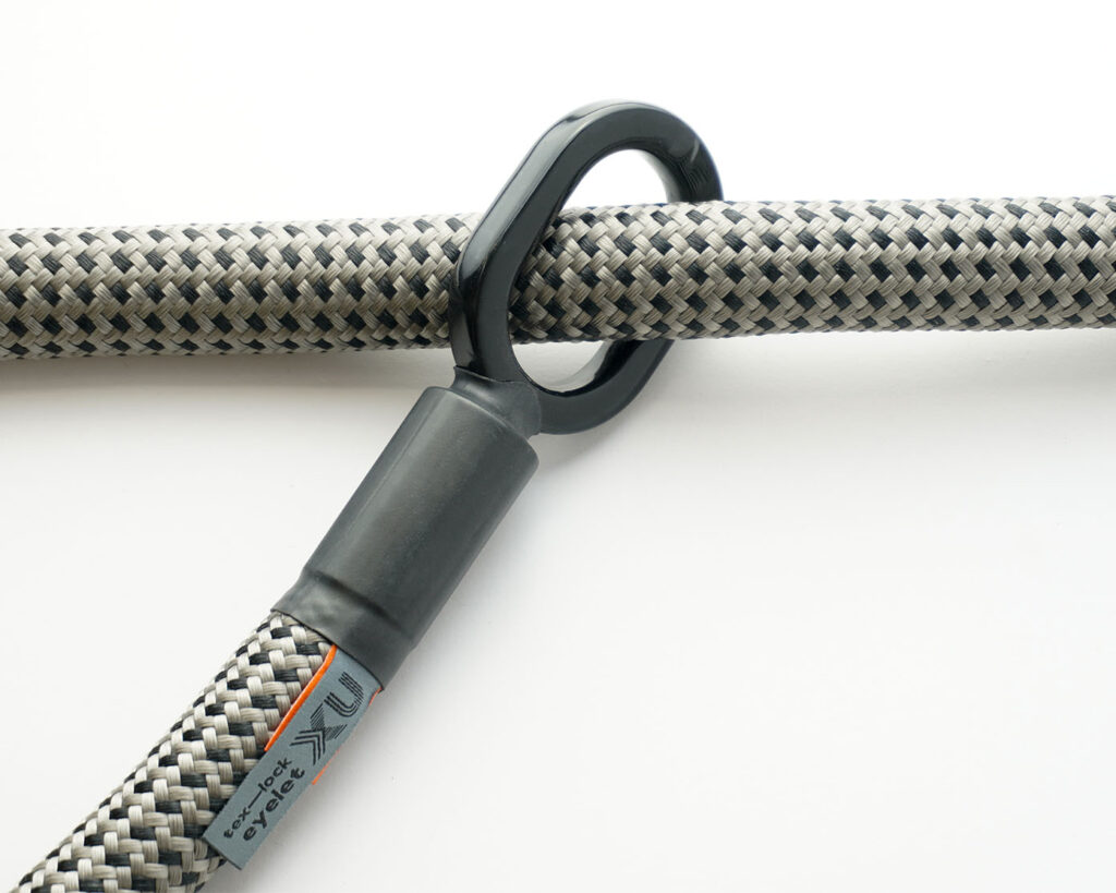 textile rope with a gray-black pattern through one of the two rubberised metal loops of the 'tex–lock eyelet'