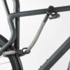 Rear wheel and top tube of the bike connected to the bike stand with U-lock and textile extension in gray-black