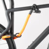 Rear wheel and top tube of the bike connected to the bike stand with U-lock and orange textile extension
