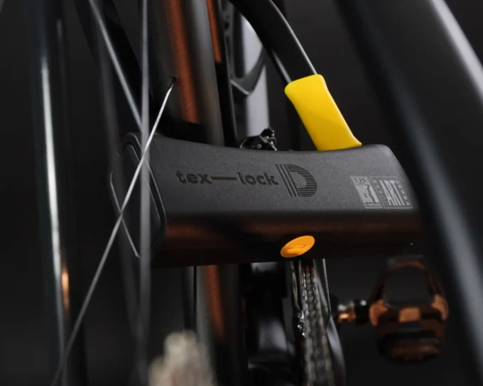 D-lock Bügelschloss in schwarz-gelbem tex-lock Design sichert Fahrradrahmen und Hinterrad