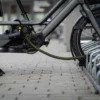 U-slot met textielkabel in zwart en neongeel patroon vergrendelt longtail fiets aan fietsenrek