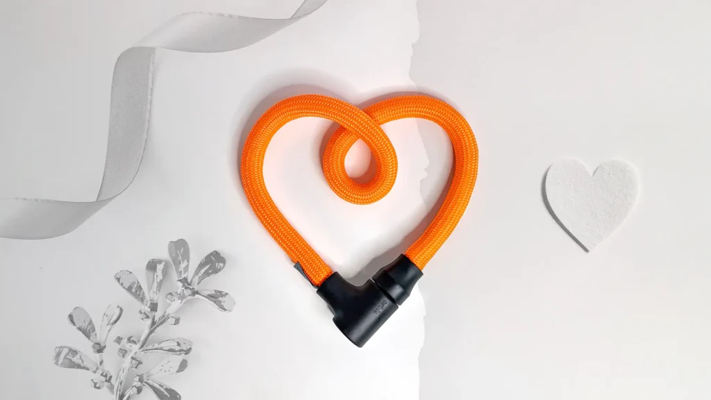 texlock orbit in acid orange als Geschenk für Radfahrer als Herz geformt vor weißem Hintergrund